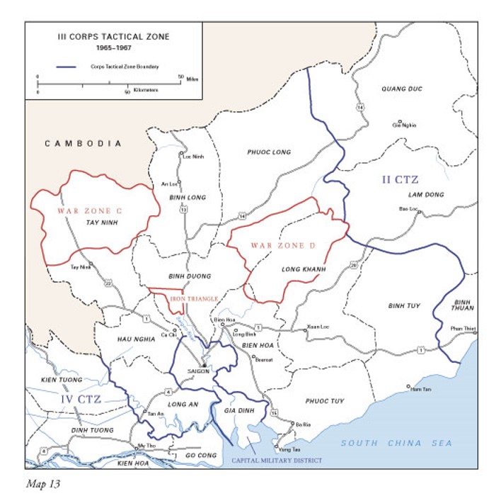 Text-book style map of the III Corps Tactical Zone from 1965-1967, according to the legend. This is the area of Vietnam around Saigon, with some of the South China Sea visible to the south at the bottom and Cambodia to the north west in the upper left portion. Major highways and cities are indicated on the map, but the main points are the color highlighted boundaries of the two war zones and the iron triangle, which are all in reddish organge, and the full tactical zone in a darker blue. There is text in the bottom left that says Map 13 and there is a unit bar in the legend that gives distances in both miles and kilometers.